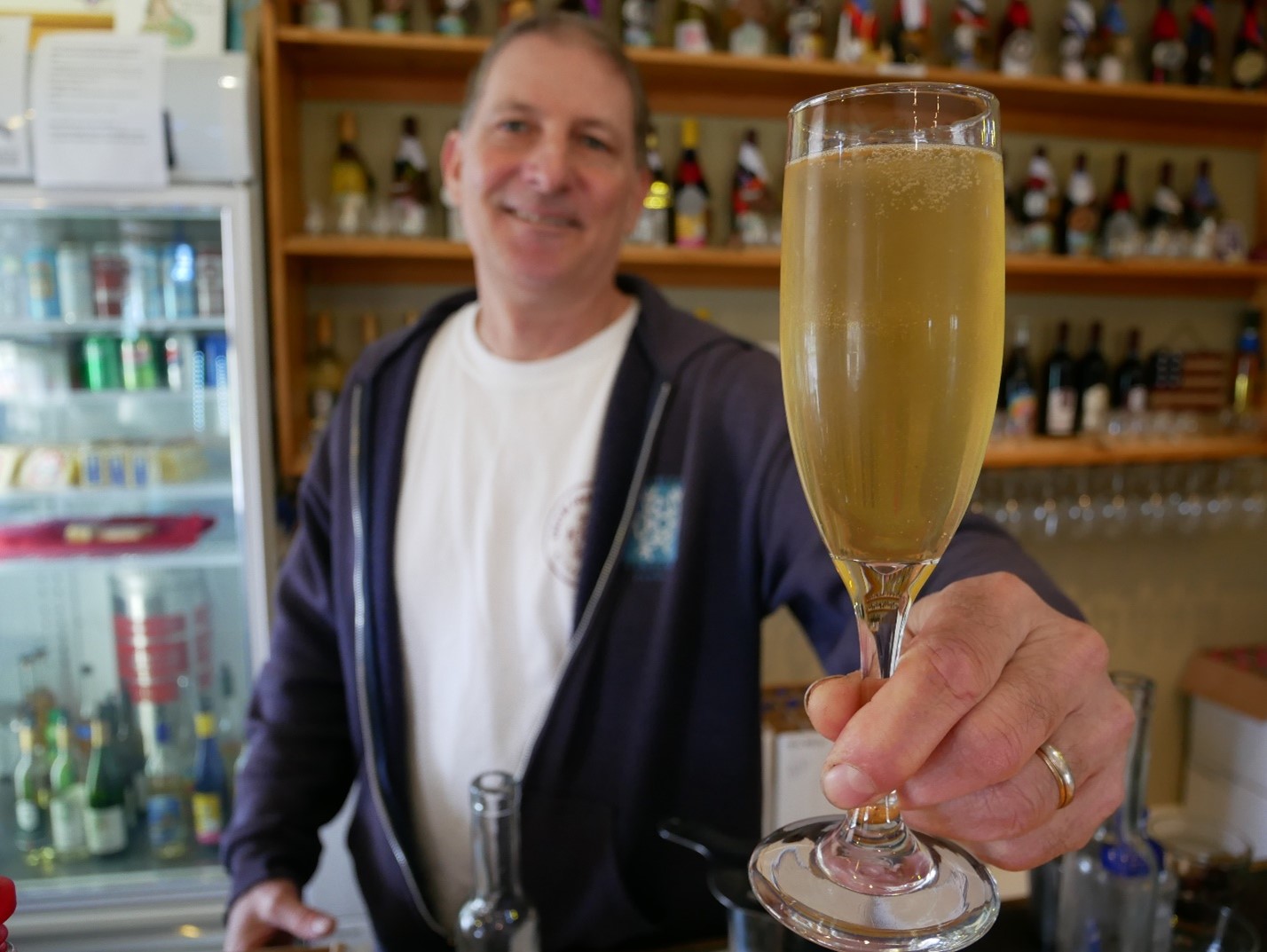 Person toasting with spring cocktail in champagne glass
