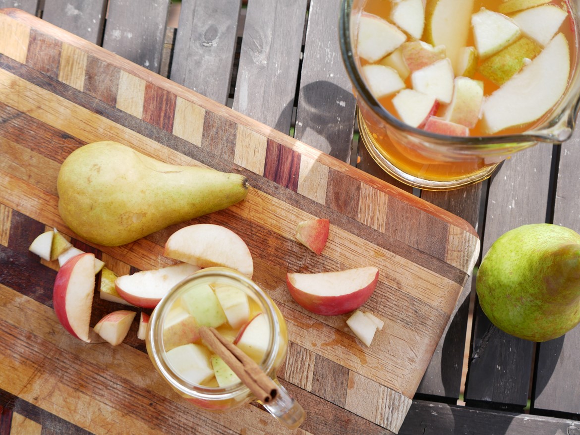 fall sangria pitcher and glass on cutting board apples